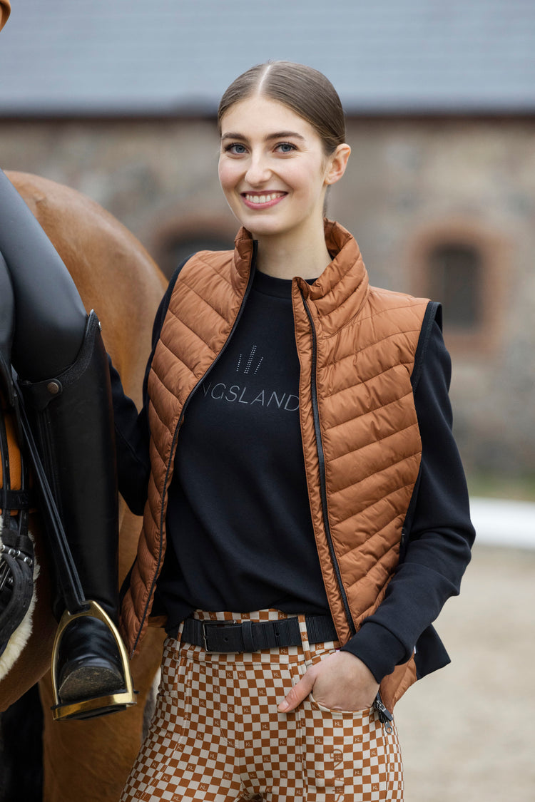 Woman wearing Kingsland clothing standing next to horse