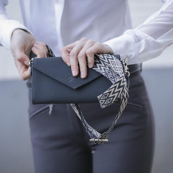 Penelope perforated riding phone bag with stylish geometric patterned strap.