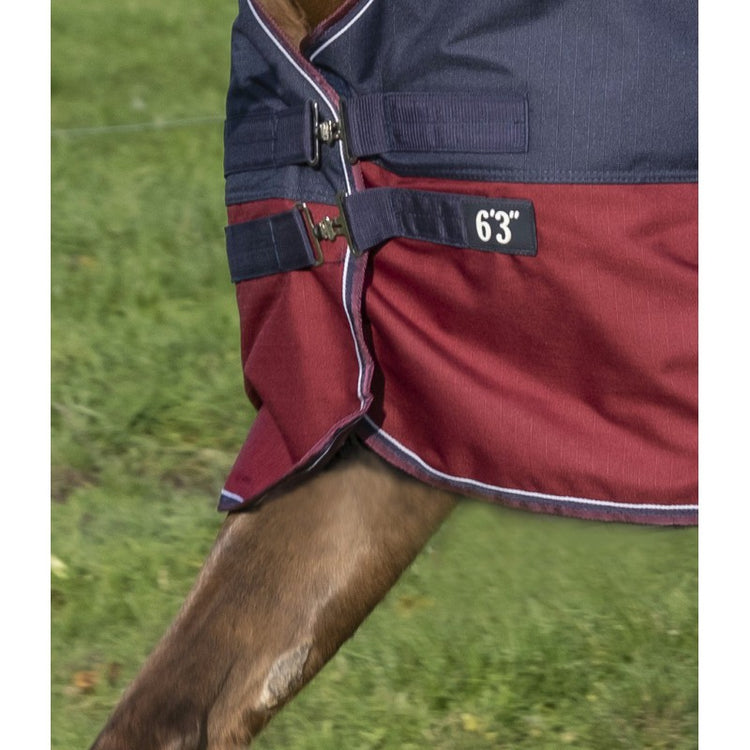 Waterproof and breathable High neck turnout rug in 1200 Denier ripstop polyester with taped seams and nylon lining. Features a very large waterproof tail flap decorated with a reflective strap, low-cross surcingles and thigh straps