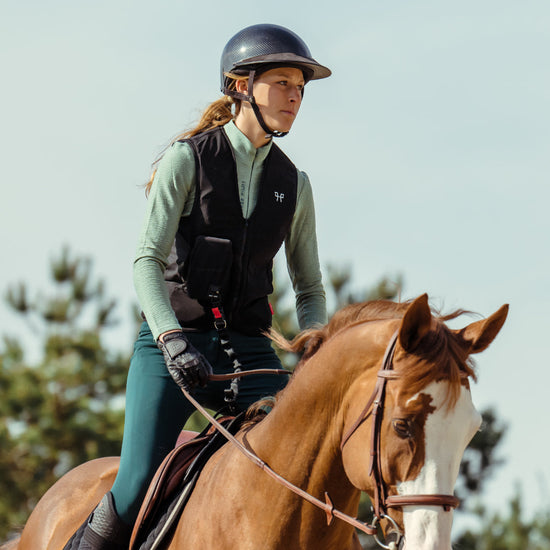 Horse rider wearing a Horse Pilot Air Vest on a chestnut horse