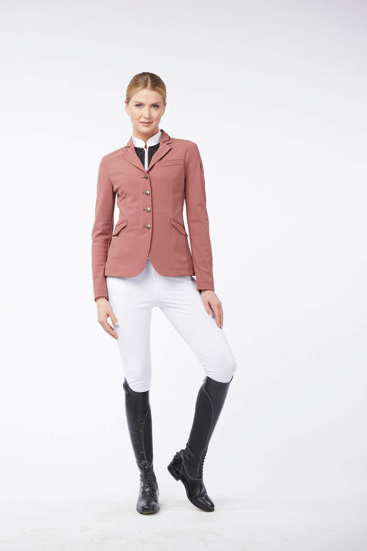 Woman wearing a pink Vestrum riding jacket and white breeches