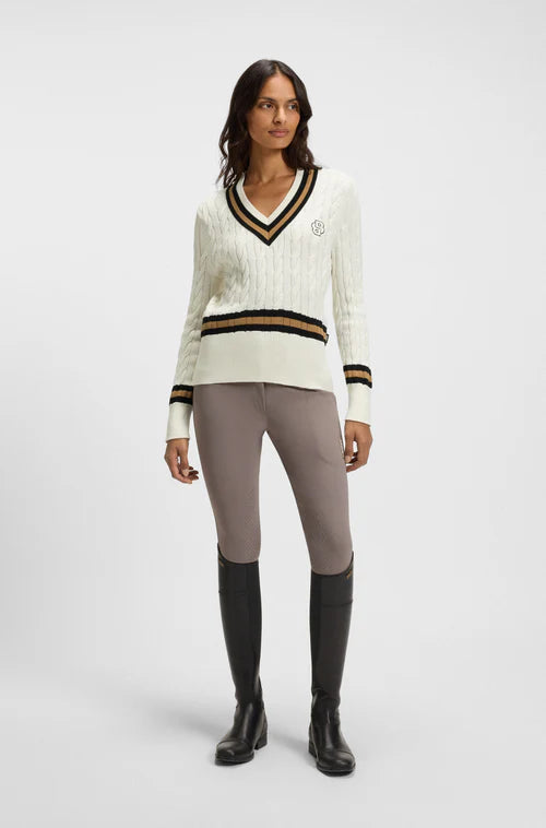 Woman wearing Boss Equestrian outfit cream sweater and beige riding breeches
