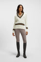 Woman wearing Boss Equestrian outfit cream sweater and beige riding breeches