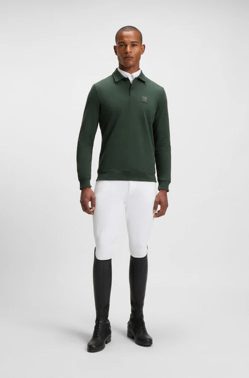 Man wearing the Boss Equestrian Dark Green Polo Sweater with white breeches