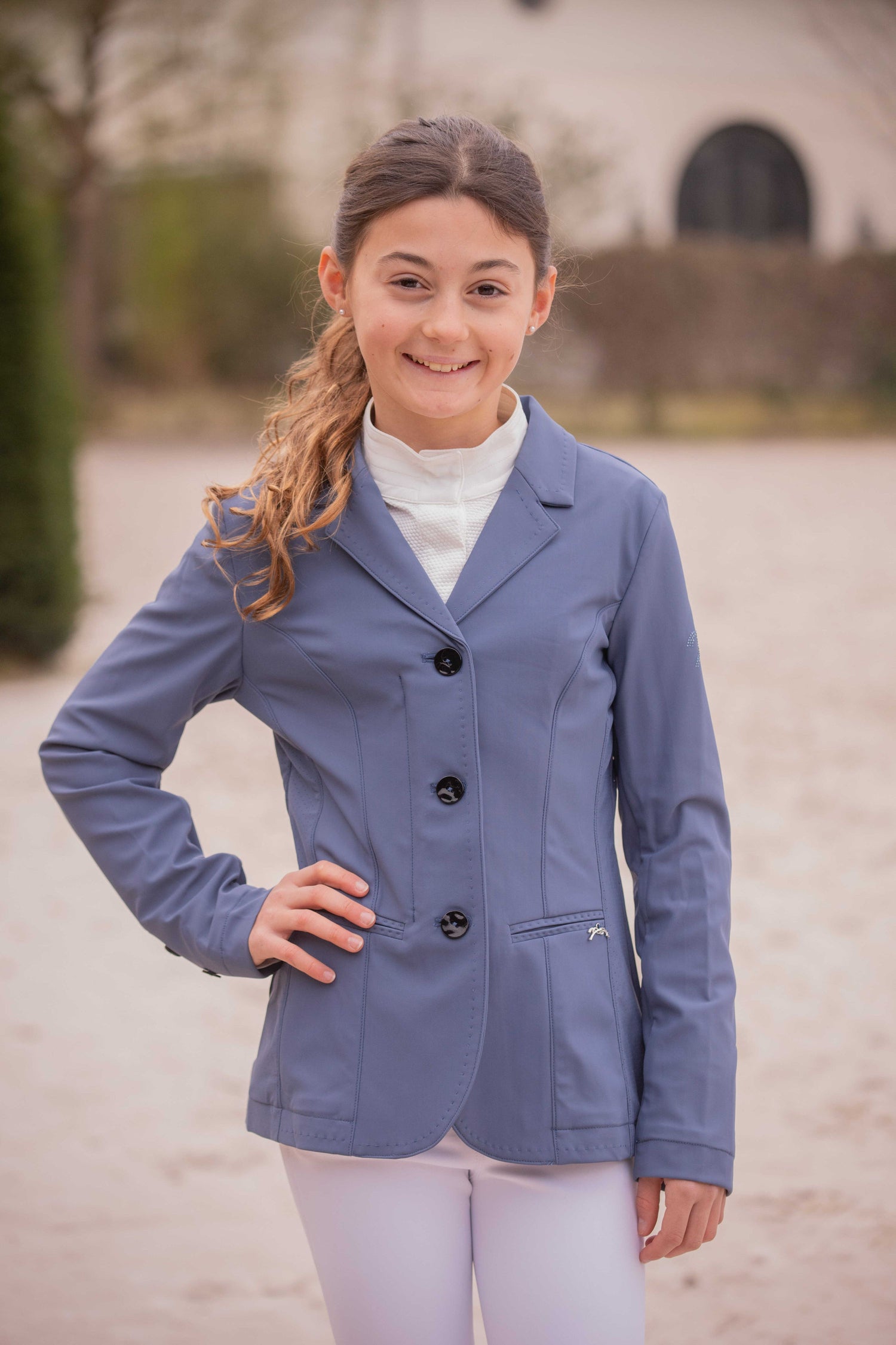 Girl wearing a blue equestrian competition jacket