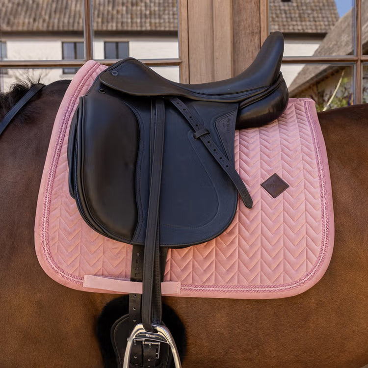 Anatomical dressage saddle pad with girth strap for a practical fit.