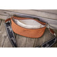 Cognac leather waist bag designed for carrying a phone, wallet and keys hands-free.