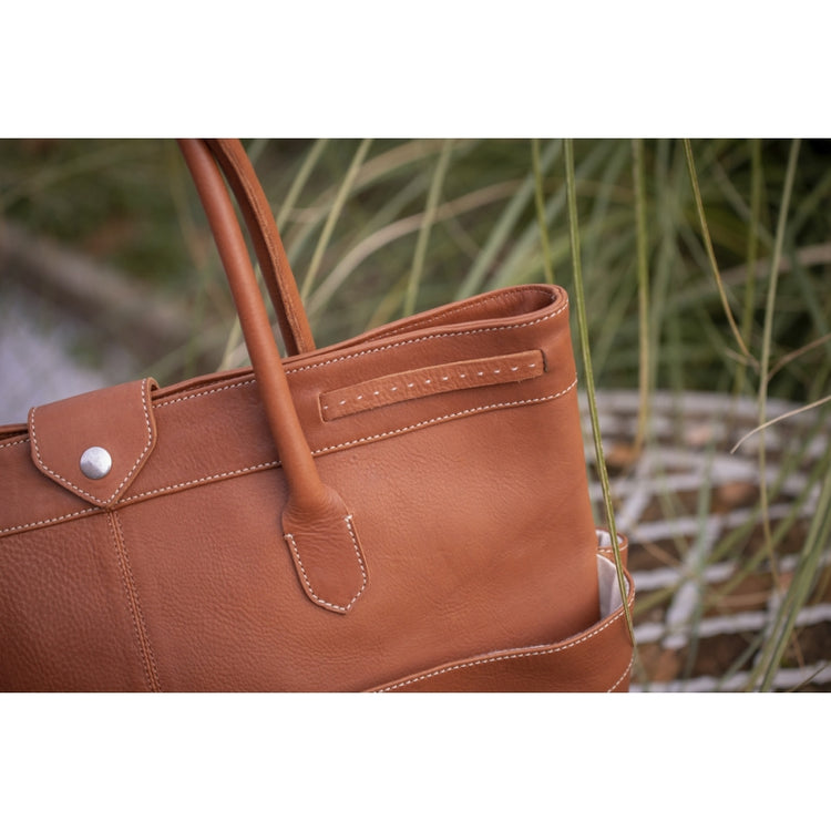 Leather horse grooming bag for storing brushes and grooming equipment.