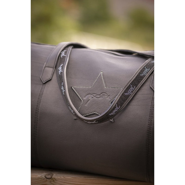 Leather travel bag for women with practical handles and shoulder strap.