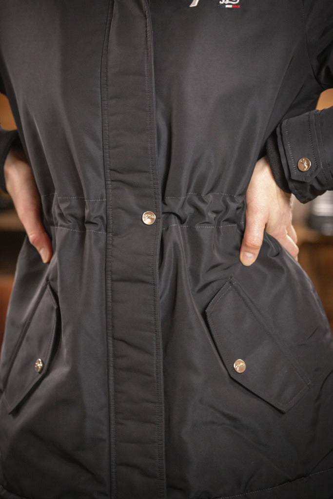 Long winter riding jacket with rear slit and adjustable waist for comfortable equestrian wear.