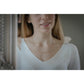 Minimalist gold equestrian necklace with a delicate and understated appearance.