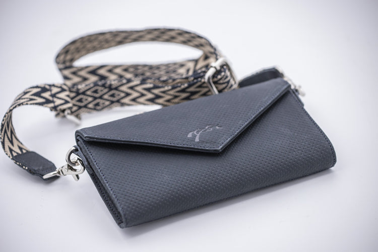 Penelope crossbody phone bag with black and off-white patterned strap.
