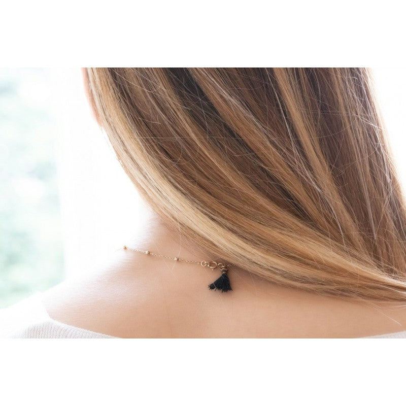 Penelope Eugénie necklace with distinctive black pompom detail at the fastening.