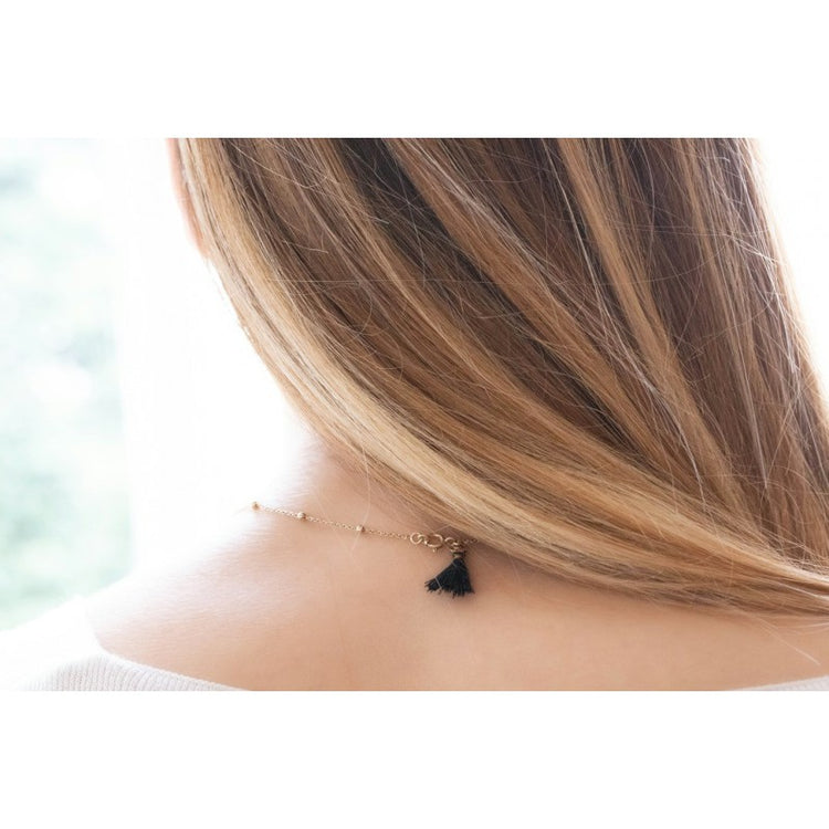 Penelope Eugénie necklace with distinctive black pompom detail at the fastening.