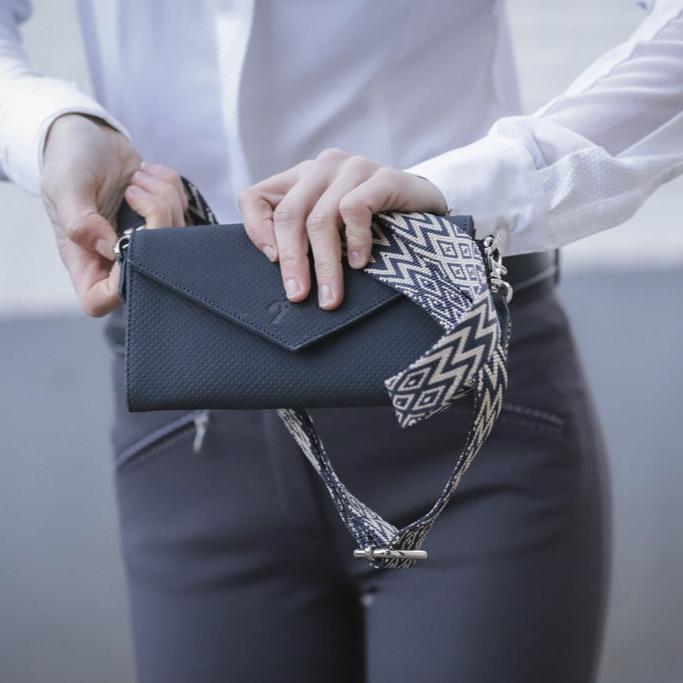 Penelope perforated riding phone bag with stylish geometric patterned strap.