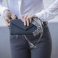 Penelope perforated riding phone bag with stylish geometric patterned strap.