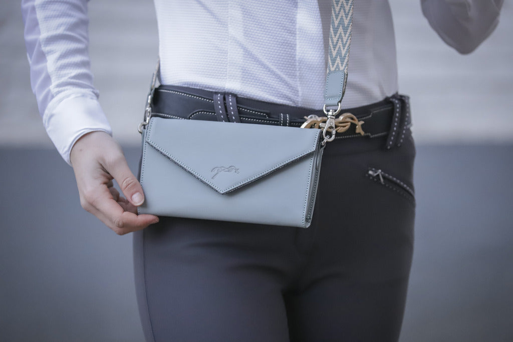 Perforated leather phone bag with compact envelope-style design for everyday essentials.