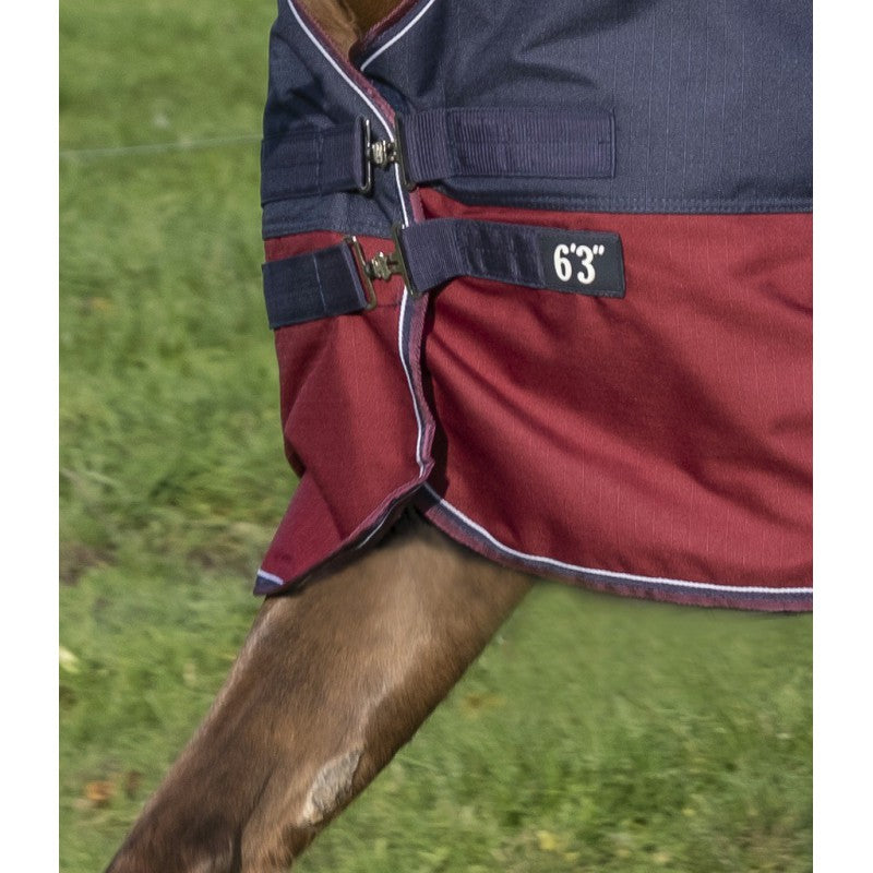 Waterproof and breathable High neck turnout rug in 1200 Denier ripstop polyester with taped seams and nylon lining. Features a very large waterproof tail flap decorated with a reflective strap, low-cross surcingles and thigh straps