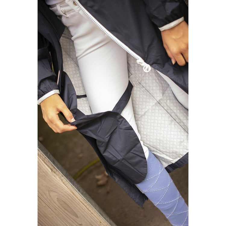 Long rain coat for horse riding with extended leg coverage.