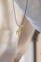 Penelope horse logo necklace with a subtle equestrian design.