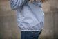 Waterproof equestrian jacket with hood for riding and outdoor stable use.